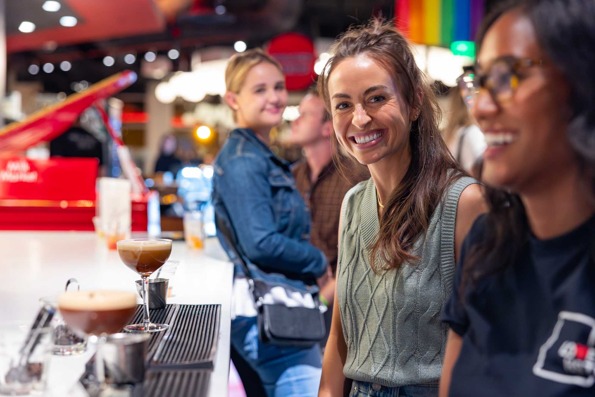 Attendees laughing and socializing at a corporate conference happy hour in Denver, Colorado.
