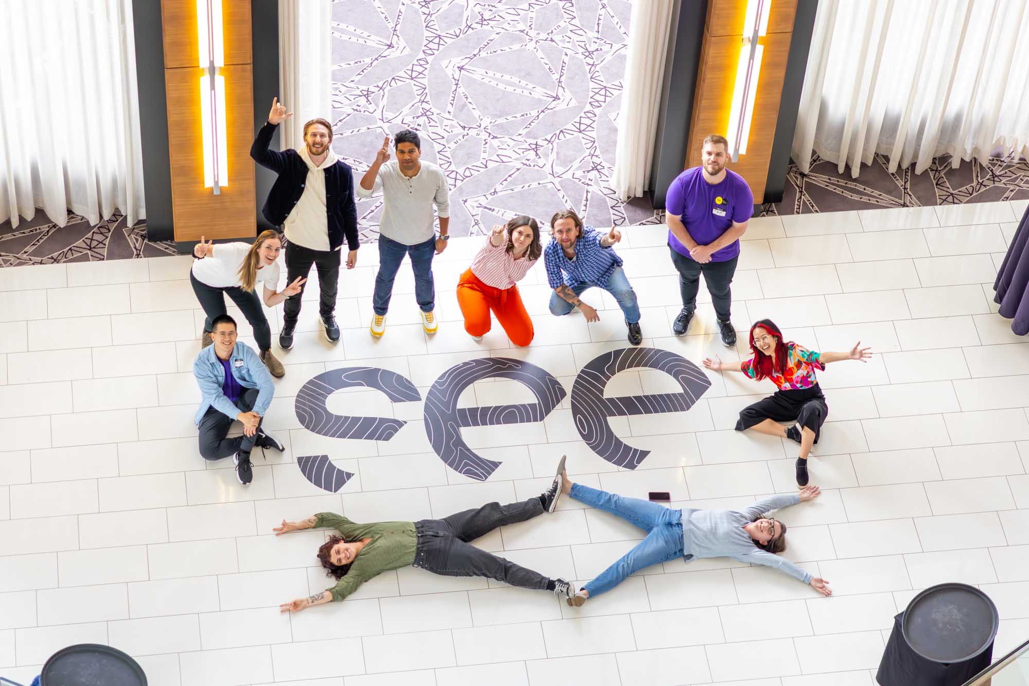 Aerial group photo of attendees arranged around the Crowdriff SEE conference logo in a Denver hotel atrium.
