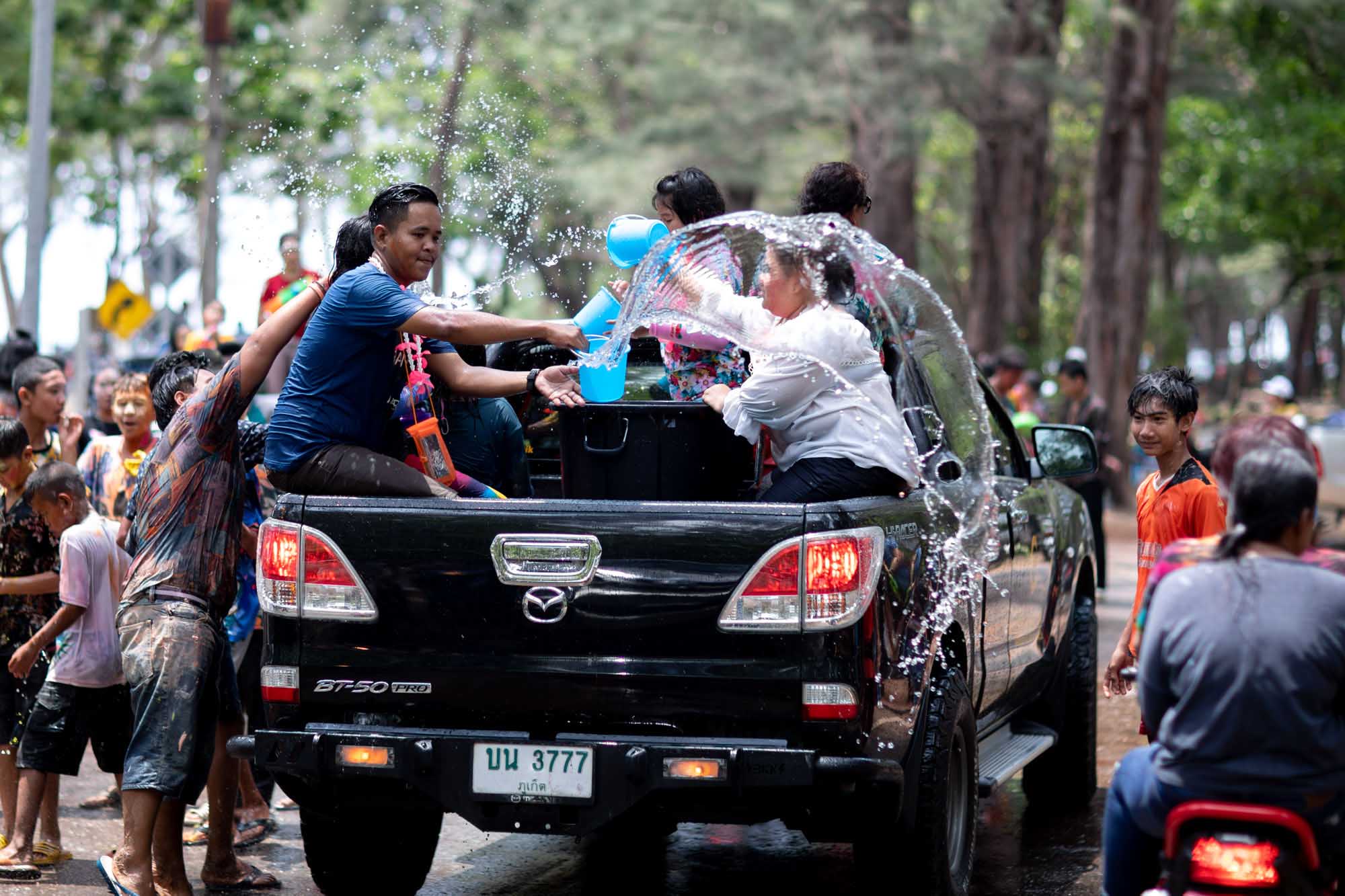 Water fight on the back of a Mazda truck during Songkran water festival in Phuket, Thailand