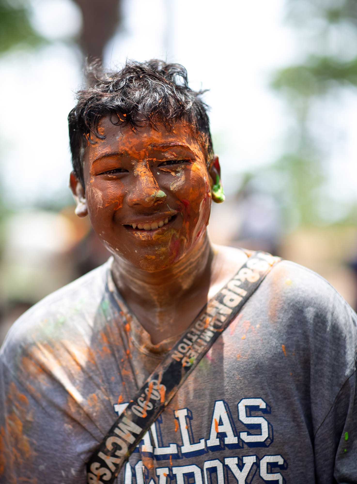 Smiling young man with paint on his face at Songkran water festival in Phuket, Thailand