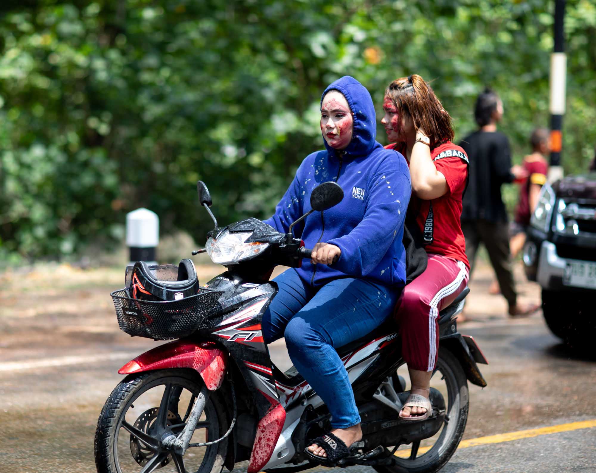 Two women on a motorbike at Songkran water festival in Phuket, Thailand