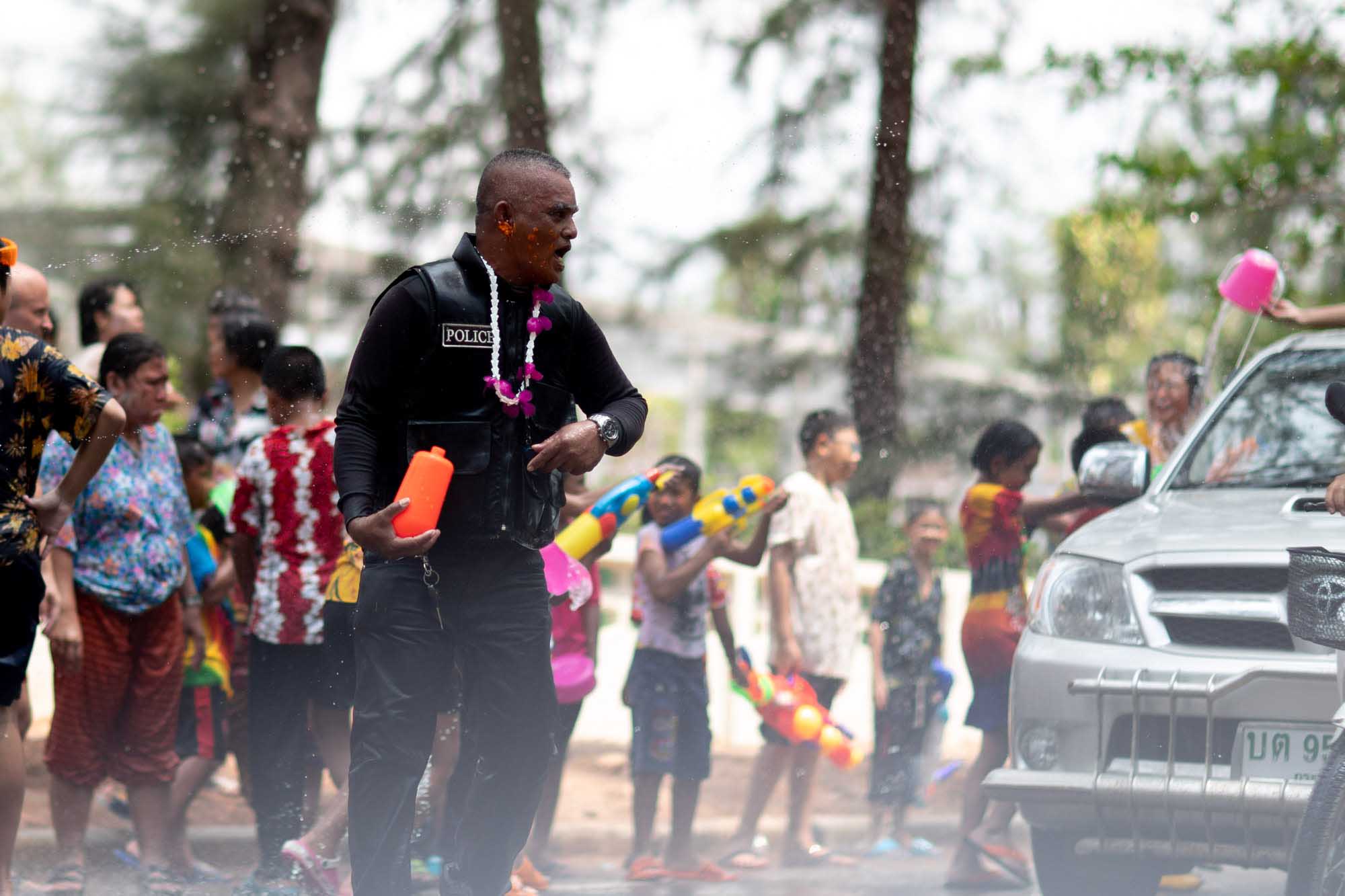 Police officer celebrates Songkran water festival in Phuket, Thailand