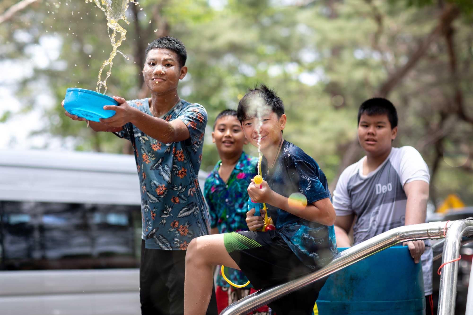 Four boys squirt water at photographer during Songkran water festival in Phuket, Thailand | Street Photography | Travel Photography | Festival Photography