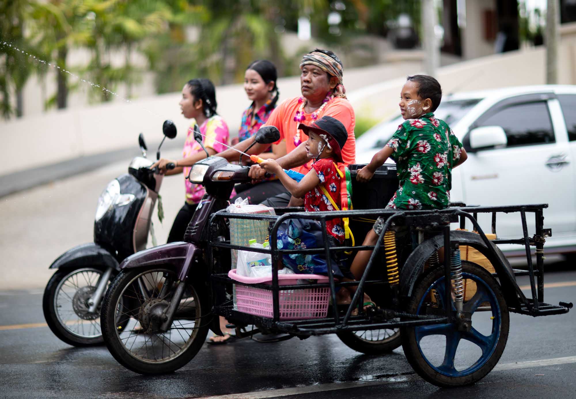 Family on motorbike during Songkran water festival in Phuket, Thailand