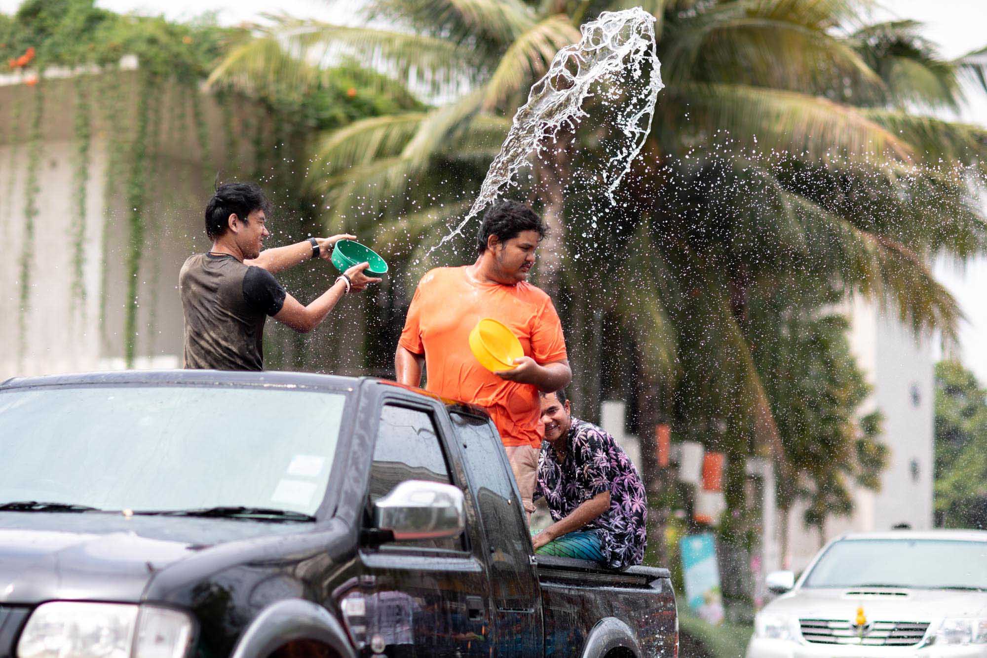 Boy splashes water from truck at Songkran water festival in Phuket, Thailand