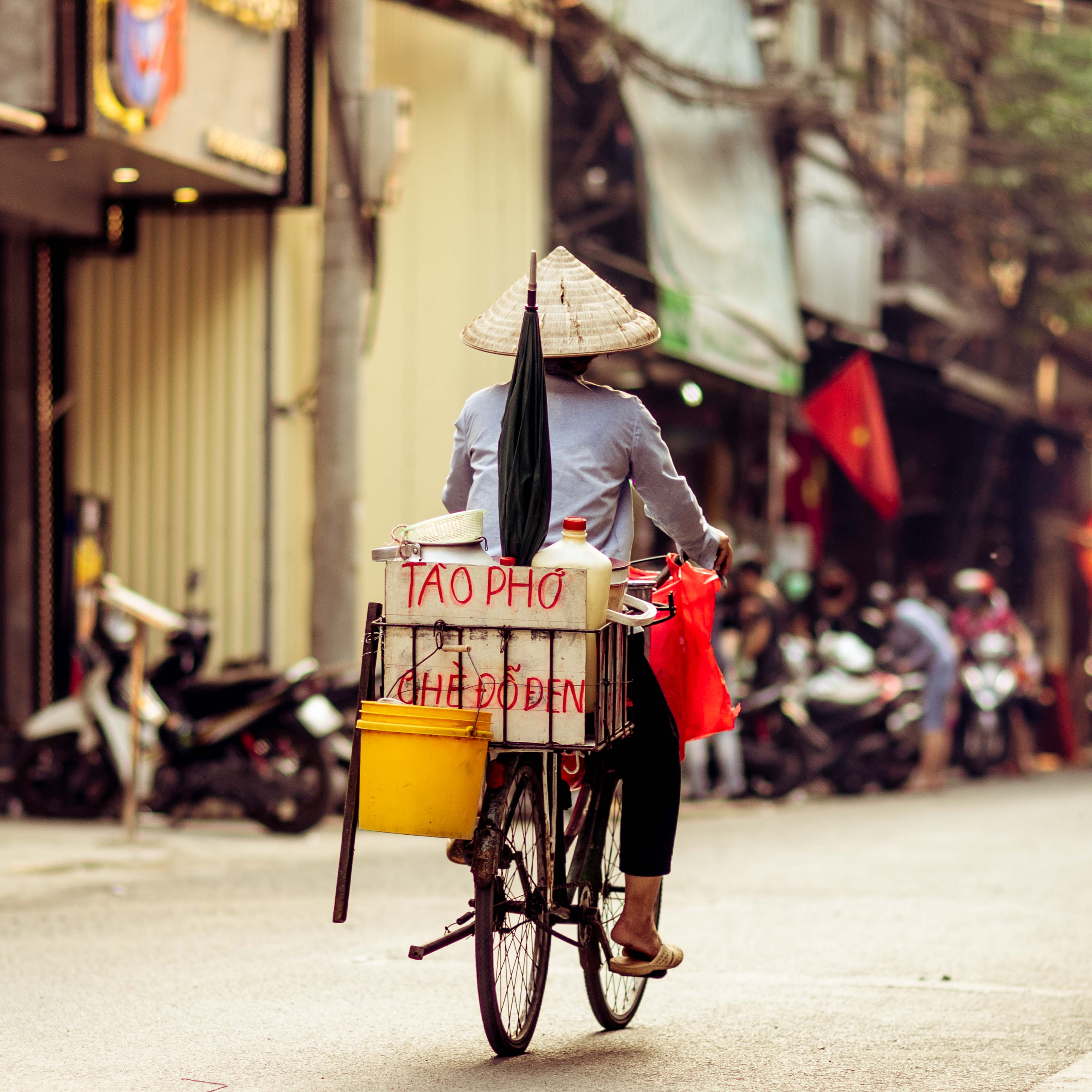 Street Photography of person riding a bike through the streets of Hanoi, Vietnam | Travel Photography