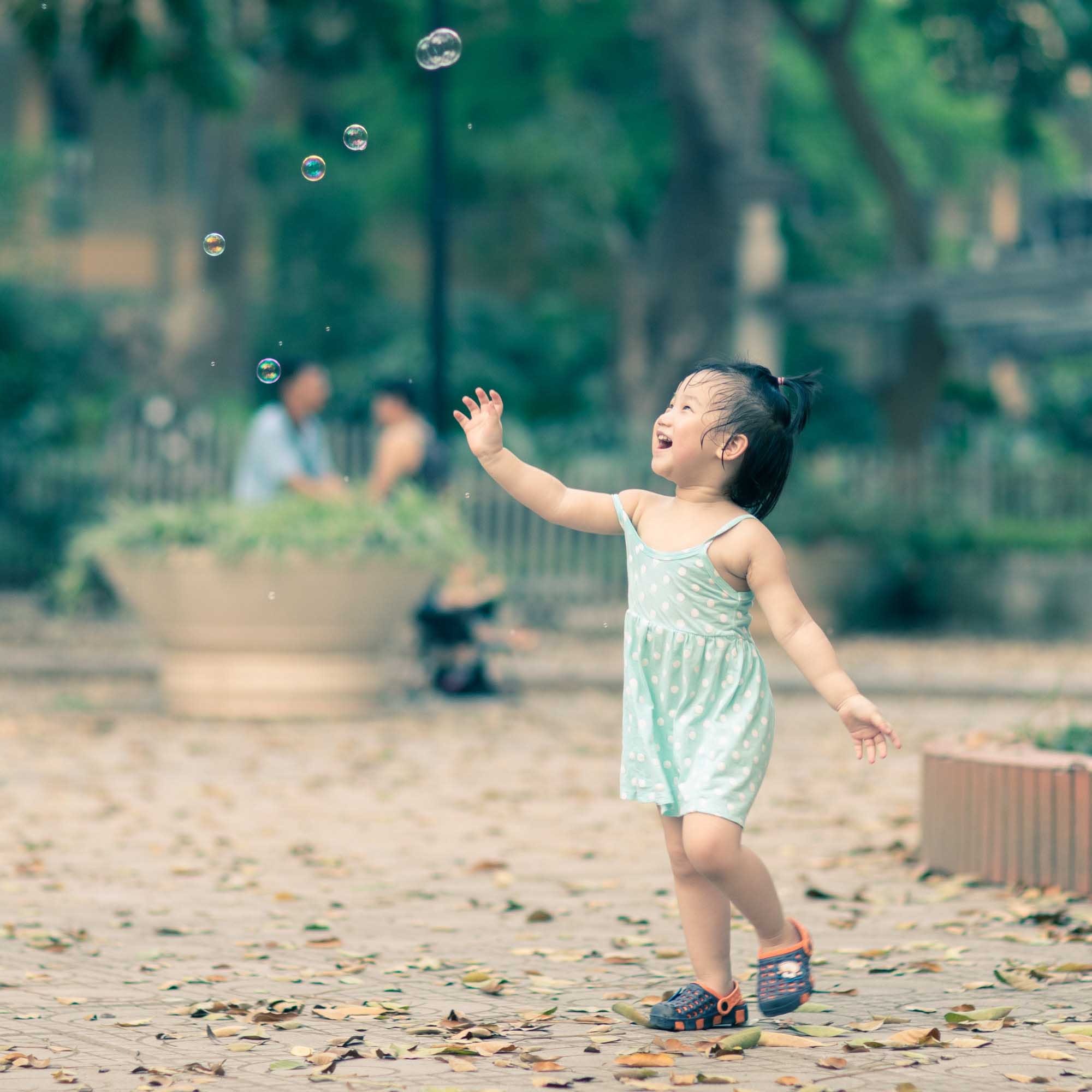 Street Photography of toddler chasing bubbles in a park in Hanoi, Vietnam | Travel Photography