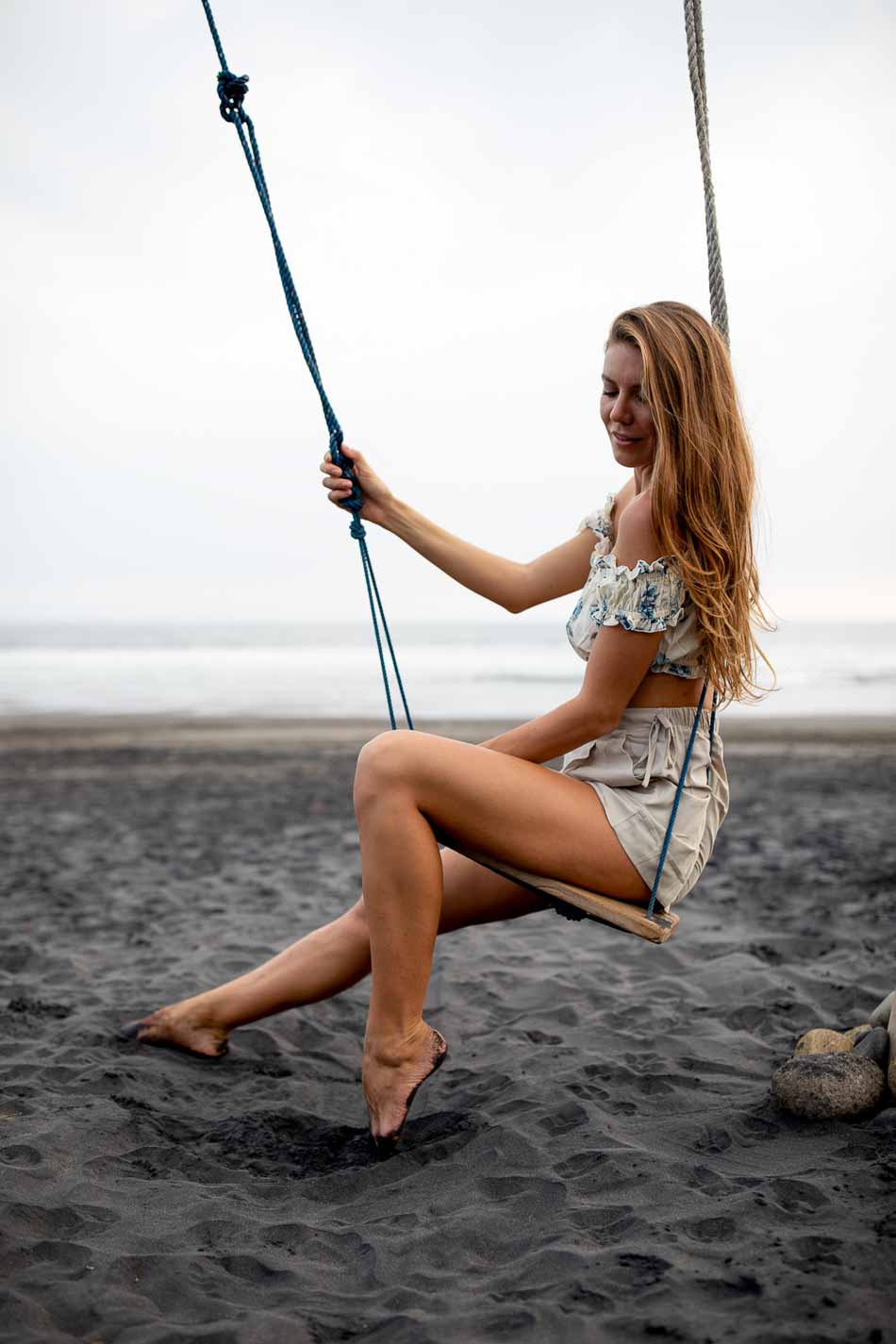 Ukrainian Model @alexa_air sits on a swing on a black sand beach | Swimwear | Lifestyle Photography | Canggu, Bali, Indonesia