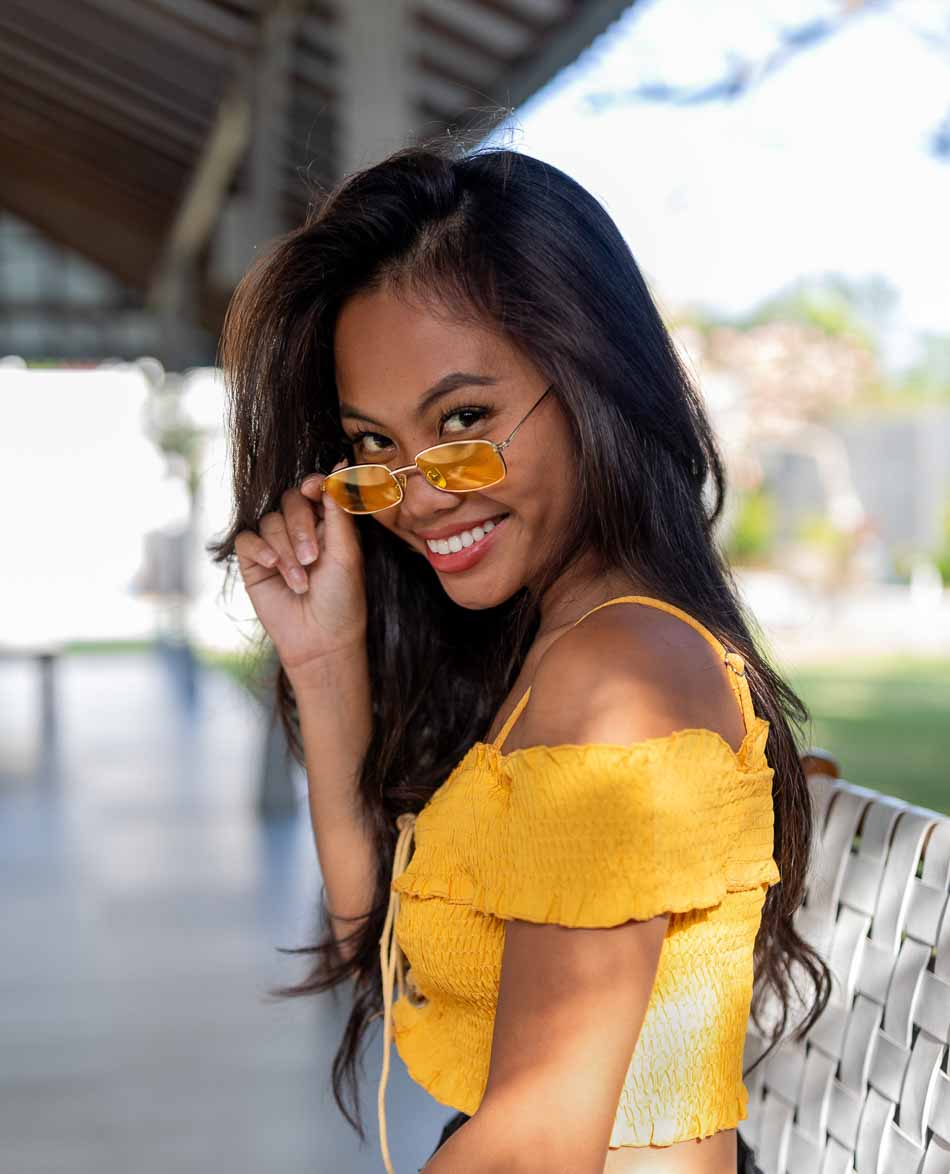 Woman in yellow shirt and sunglasses smiles for the camera | Lifestyle Photography | Swimwear Photography | Asian Bali Model | High Key Photography | Fashion Photography
