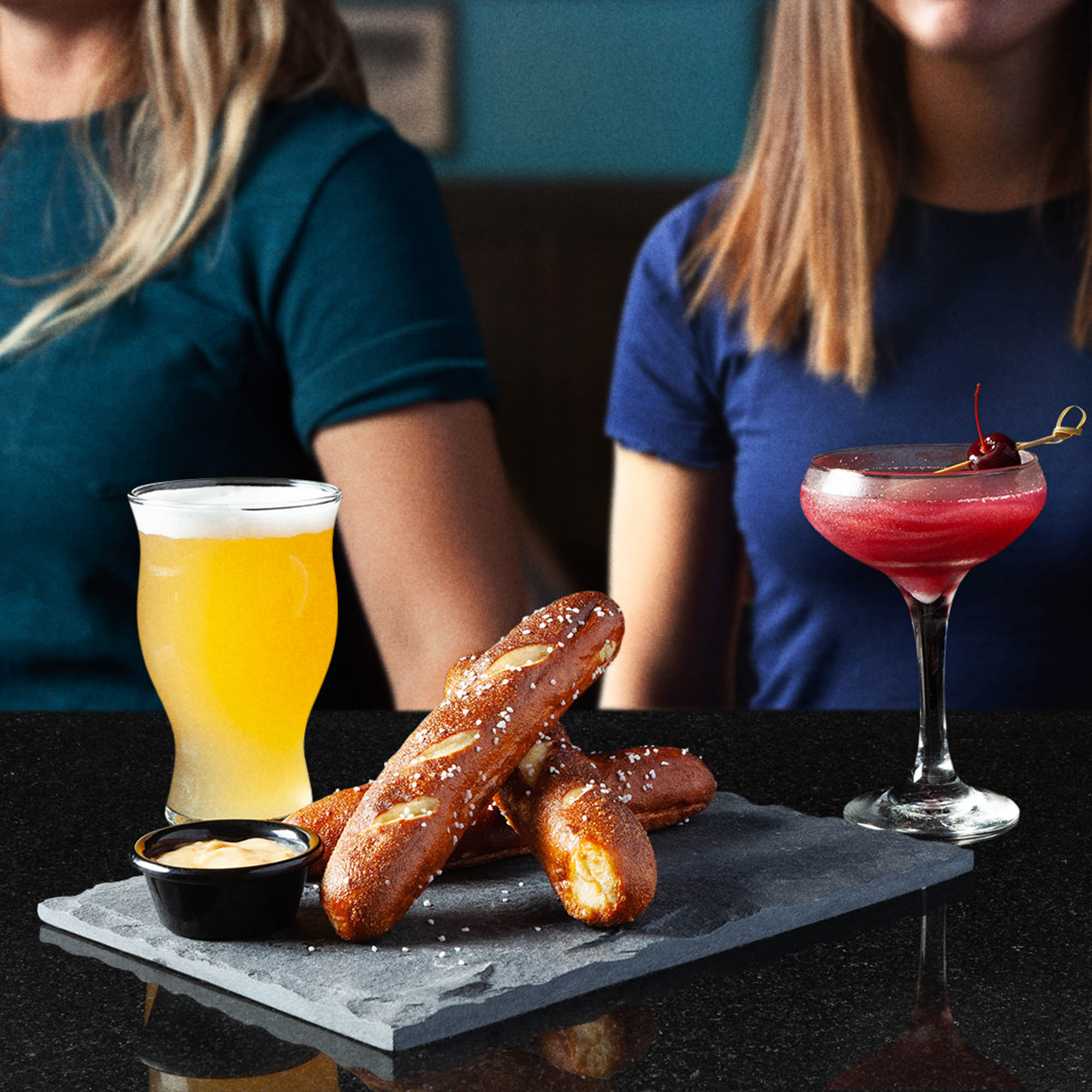 Restaurant food photography of soft pretzels with dipping sauce, beer, and a cocktail at TGI Fridays
