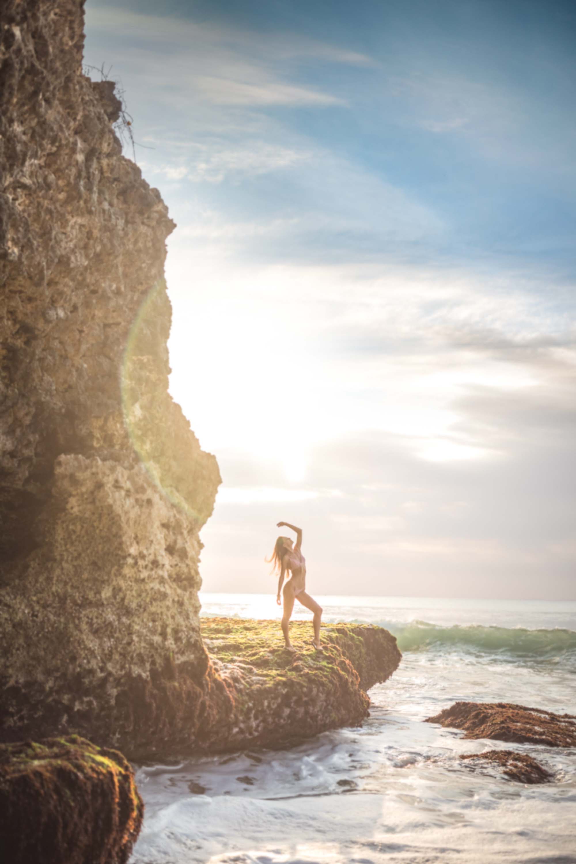 Bikini model on cliff perfect sunset with ocean in background