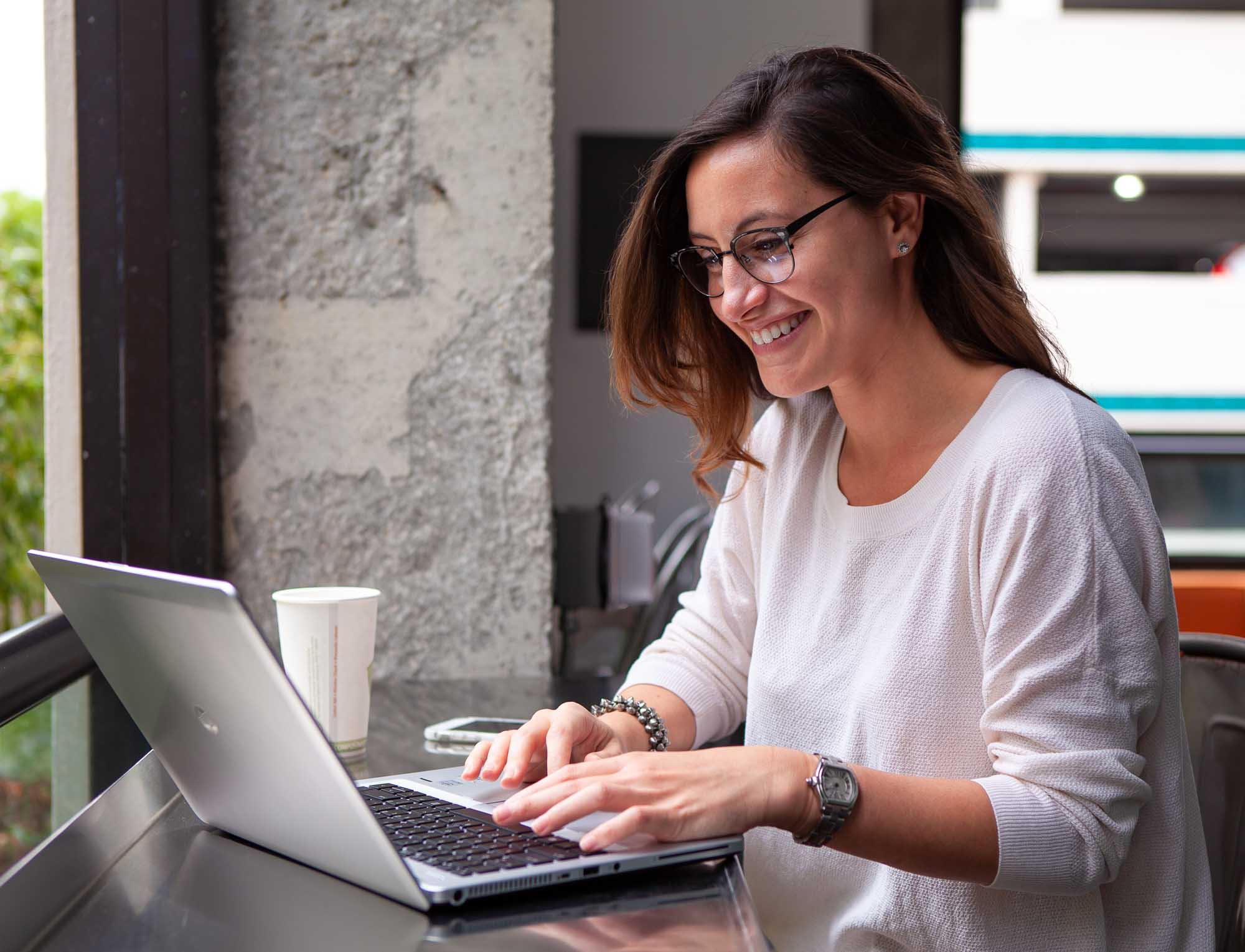 Woman smiling while working on her computer at her place of business