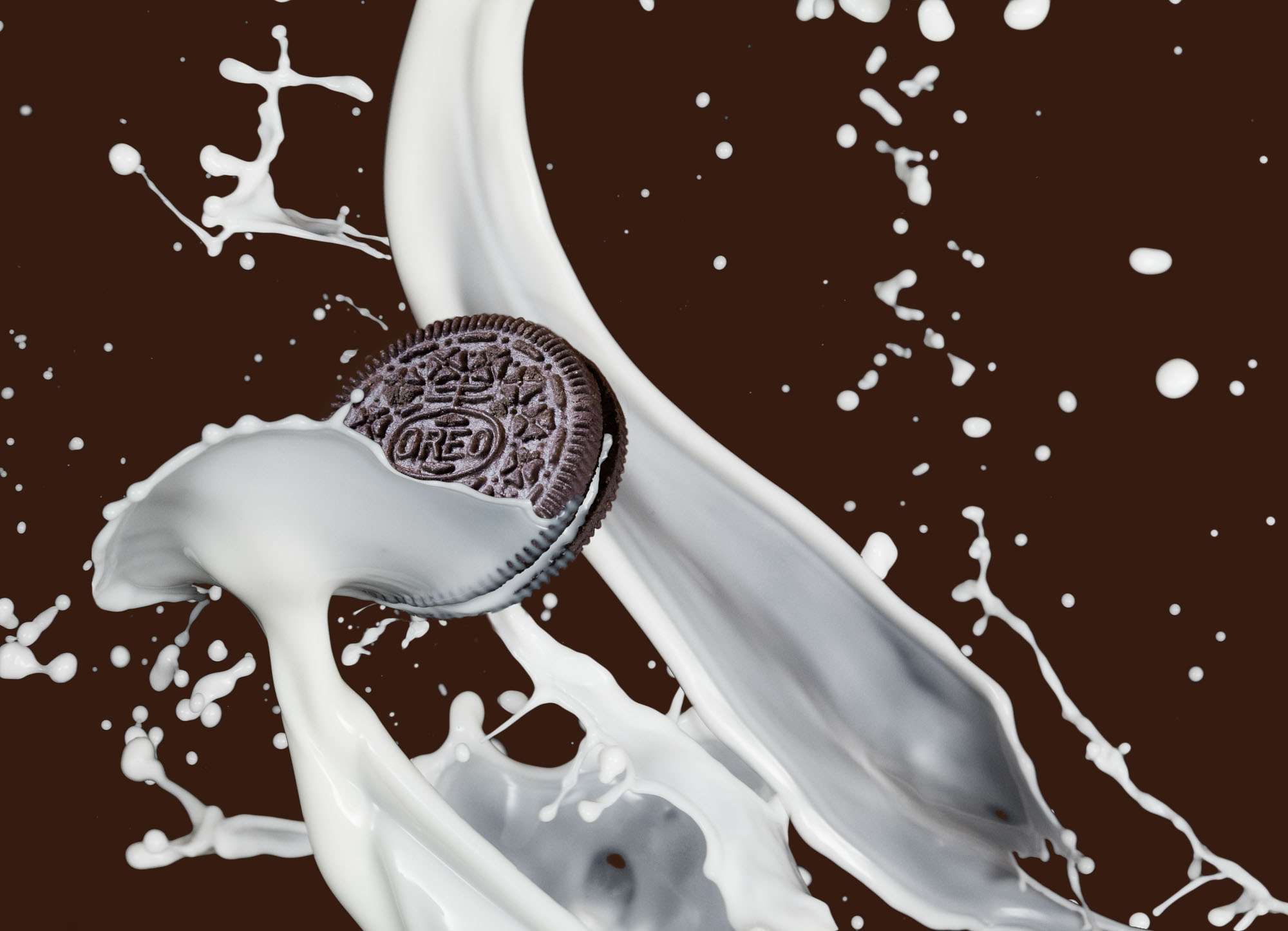 An Oreo cookie dipping into an arcing splash of milk against a chocolate-brown studio background.