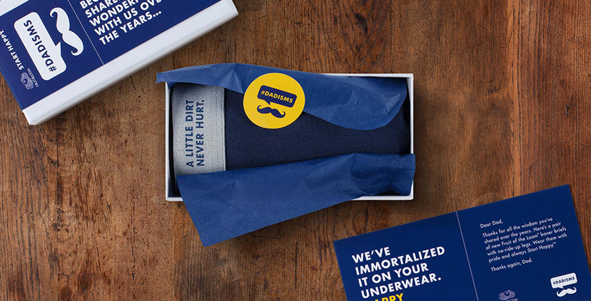 Father's Day still life for Fruit of the Loom's #DADISMS campaign — a gift box with navy tissue paper, rolled underwear, and a printed letter to Dad.