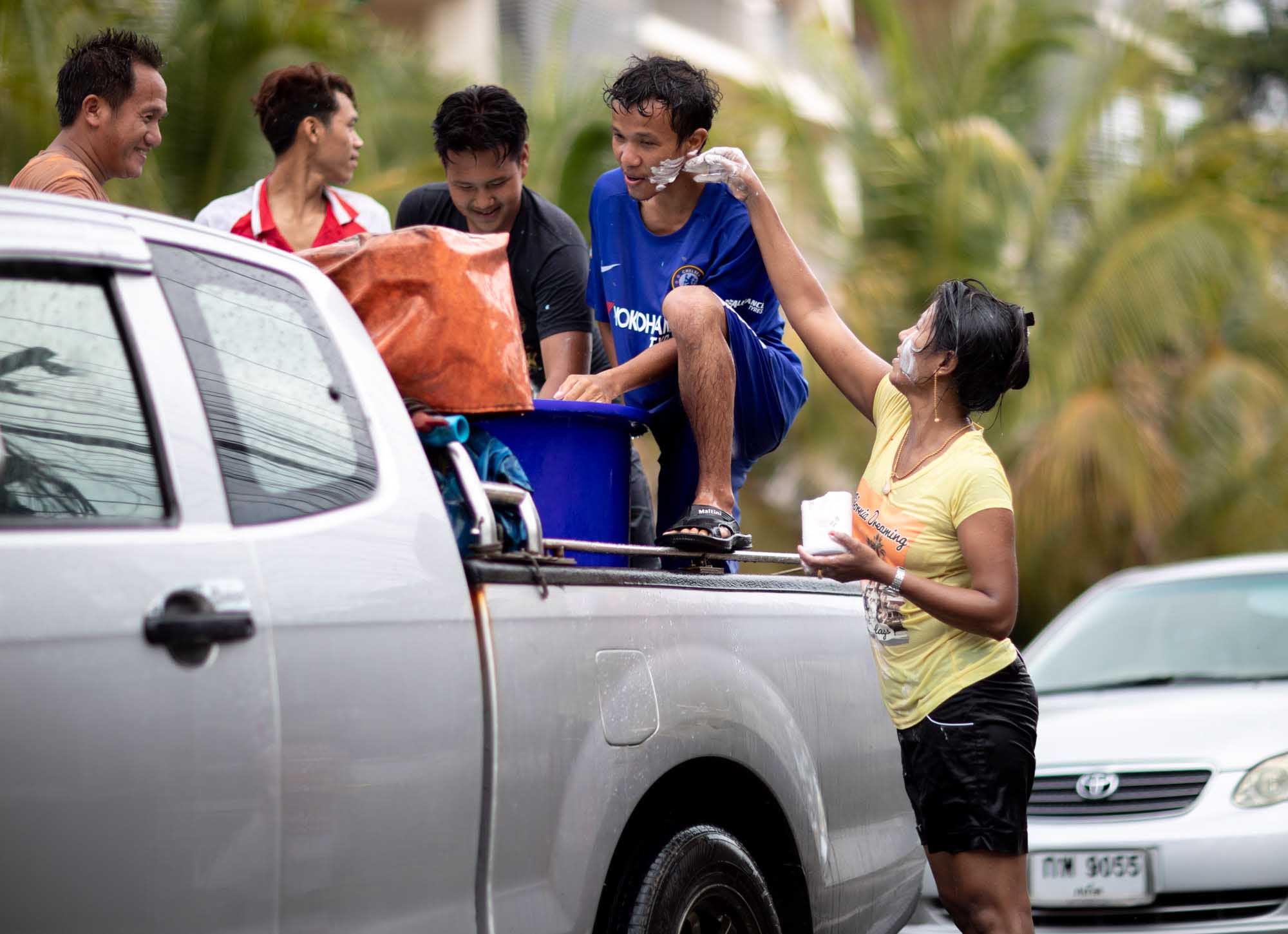 Woman paints boy's face white at Songkran water festival in Phuket, Thailand