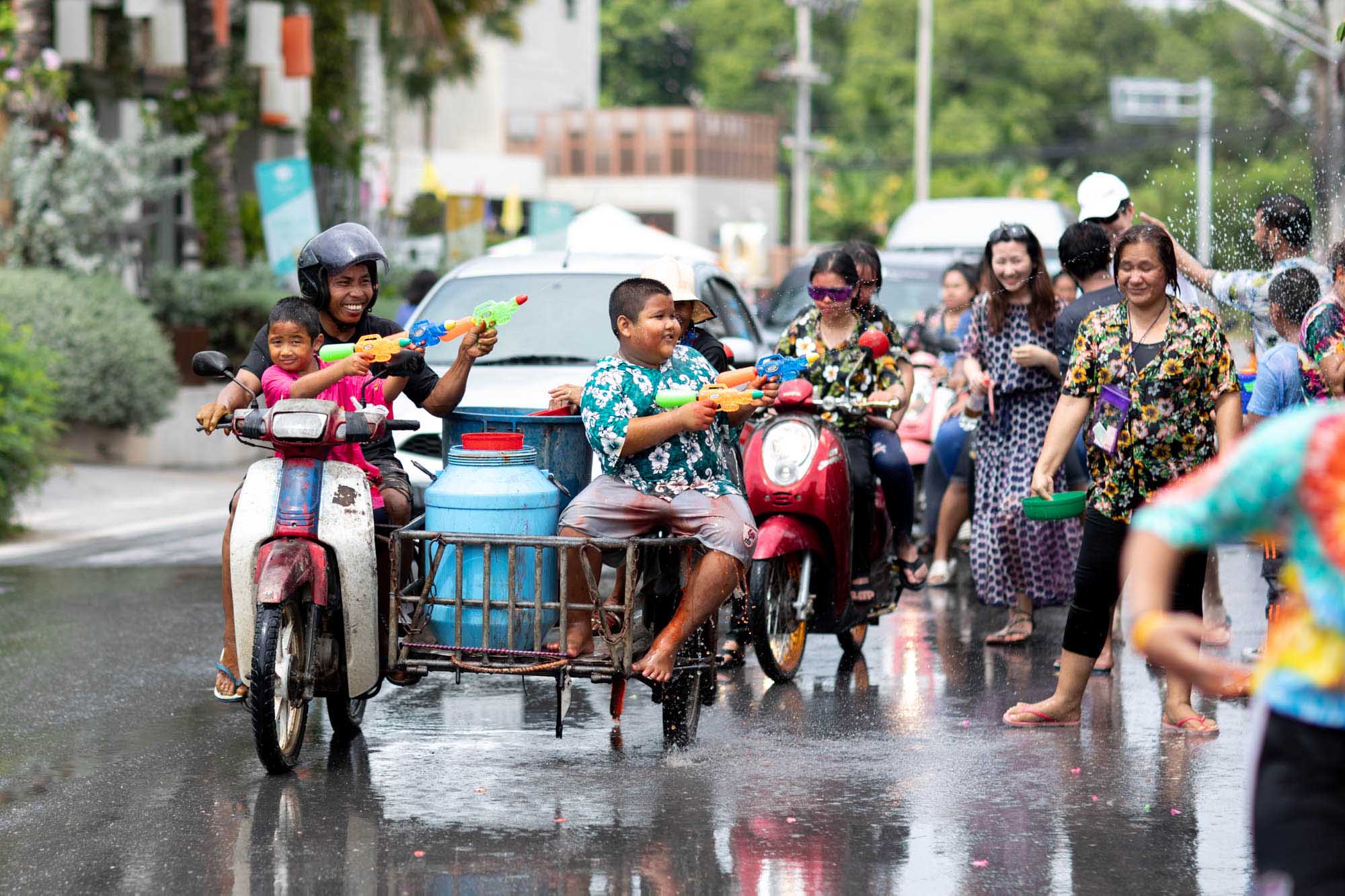 Happy family in water fight at Songkran water festival in Phuket, Thailand