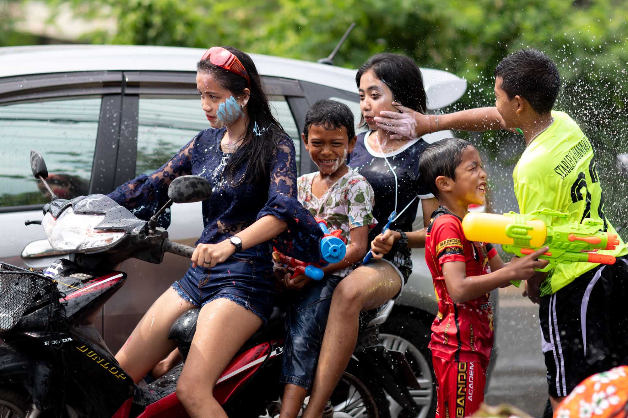 Boy paints girl's face at Songkran water festival in Phuket, Thailand